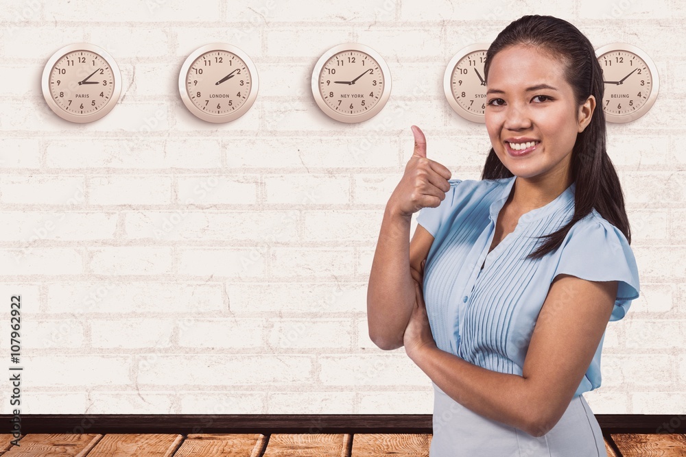 Composite image of smiling businesswoman with thumbs up 