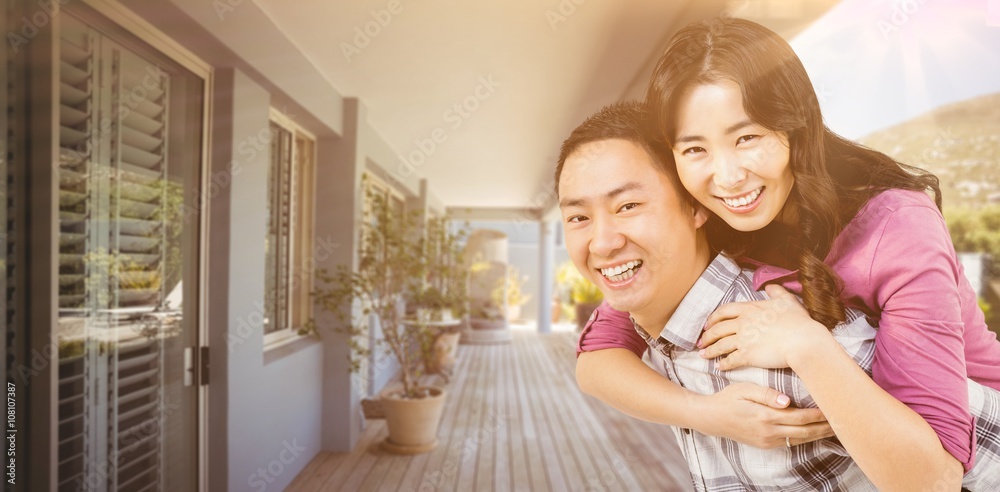 Composite image of man giving woman a piggyback