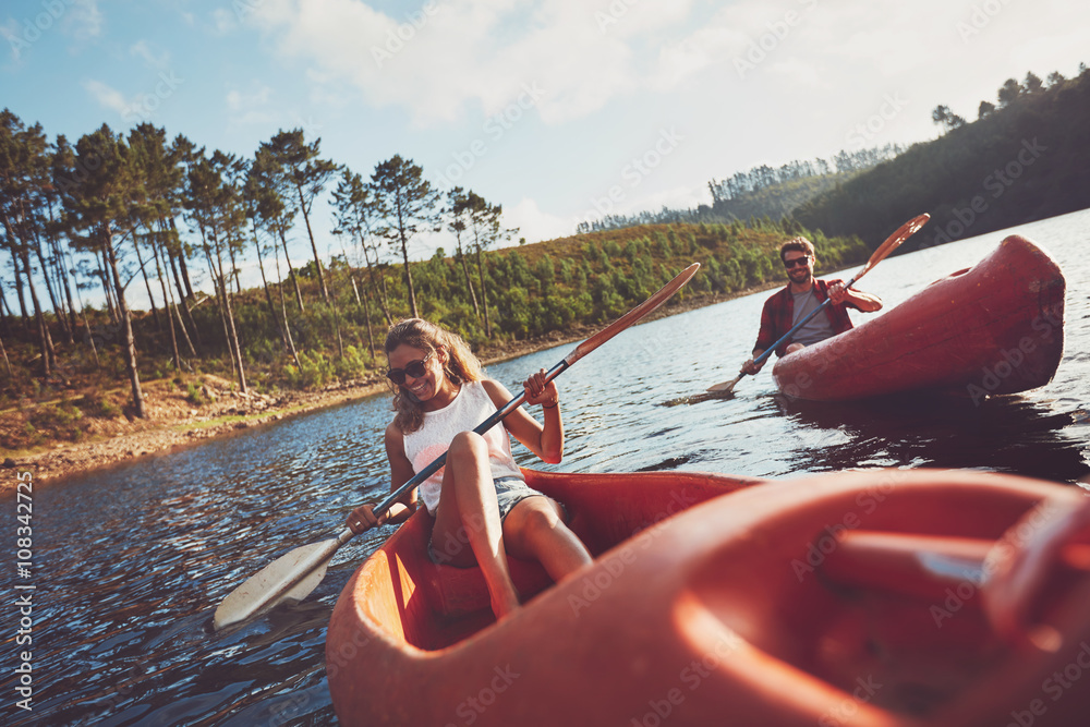 Happy young couple canoeing on lake