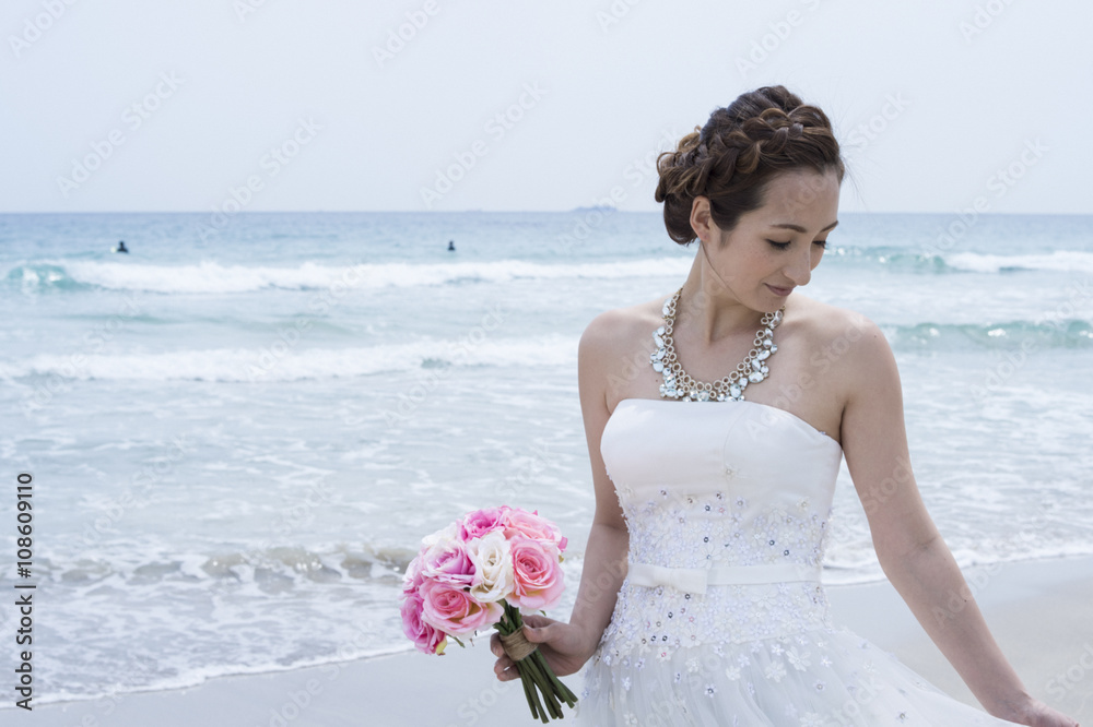 Bride wearing a wedding dress are in the beach