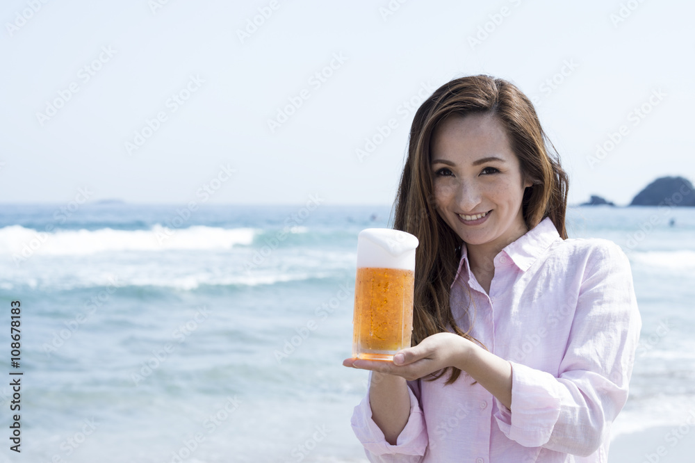 Women have a draft beer at the beach