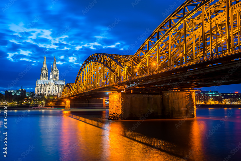 Cologne Cathedral with Hohenzollern Bridge in Cologne, Germany at night