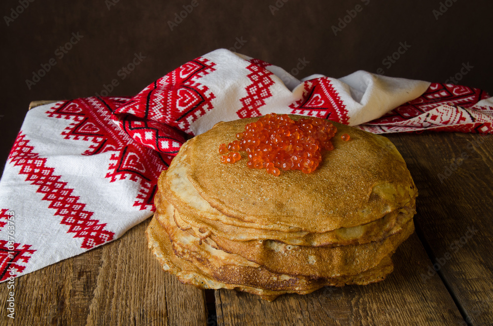 传统俄罗斯煎饼配红色鱼子酱，木质乡村背景。Maslenitsa。