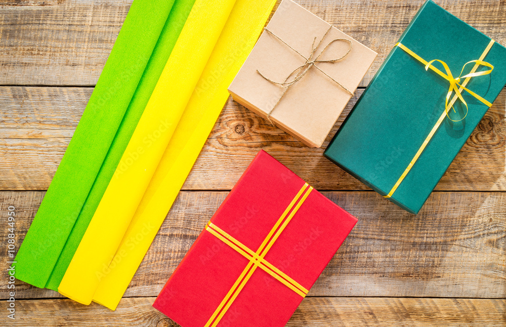 Colored gift boxes on wooden background with ribbon