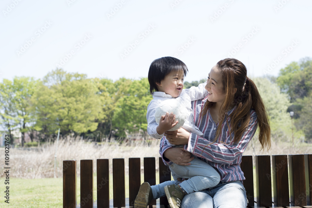 母子俩坐在公园的长椅上