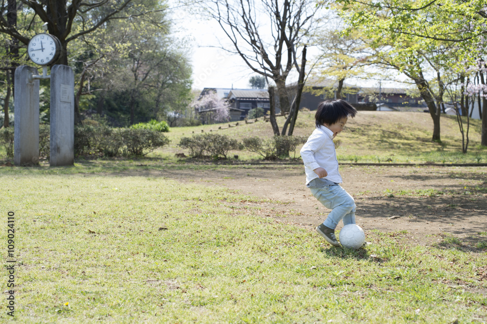 小男孩在公园里追球