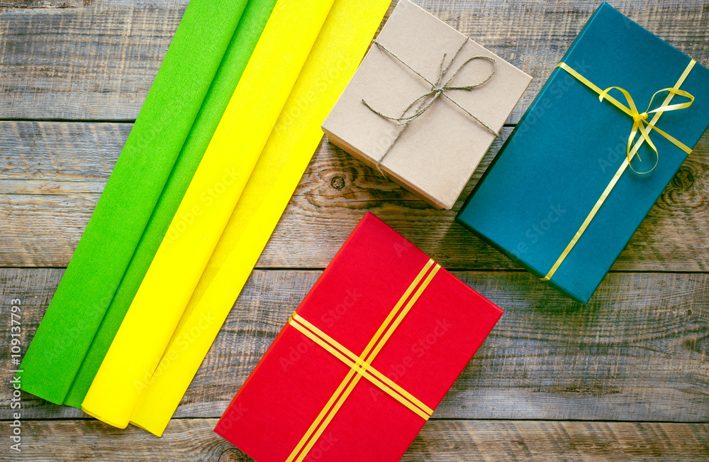 Colored gift boxes on wooden background with ribbon