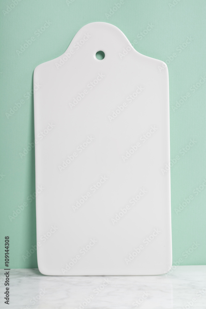 White ceramic serving board over light blue background