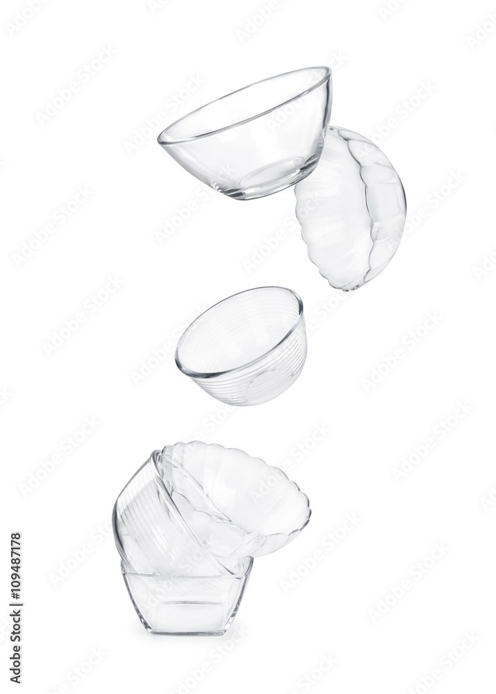 glass dishes in flight on white background