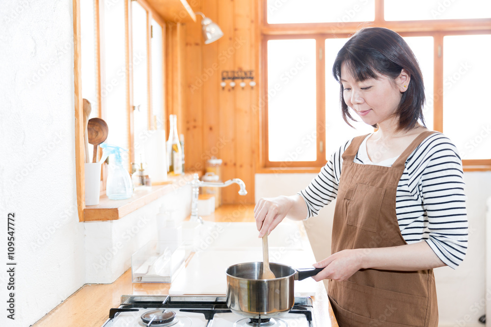 迷人的亚洲女人在ktichen烹饪