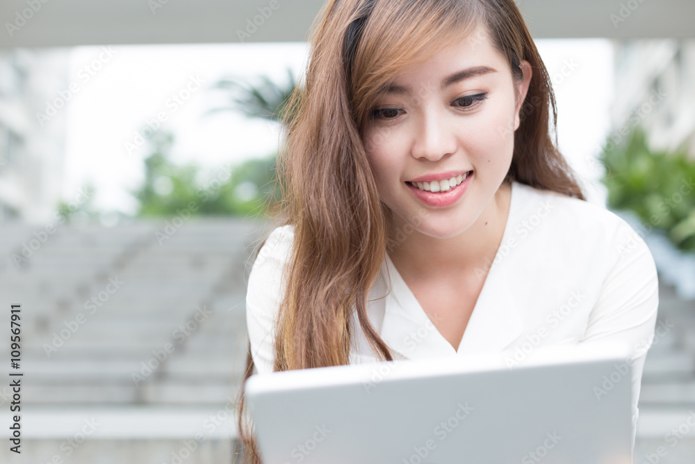 年轻漂亮的亚洲女孩在学校用平板电脑