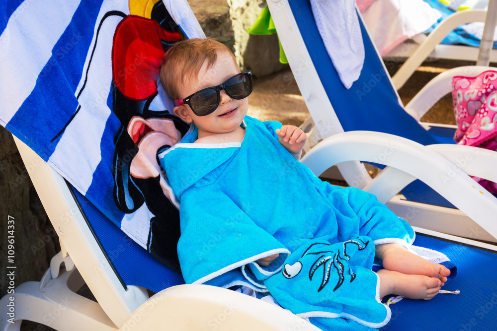 Cute baby boy in sunglasses on holidays at the pool