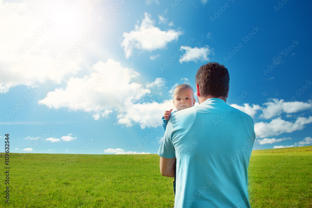 Little baby with father standing in the field