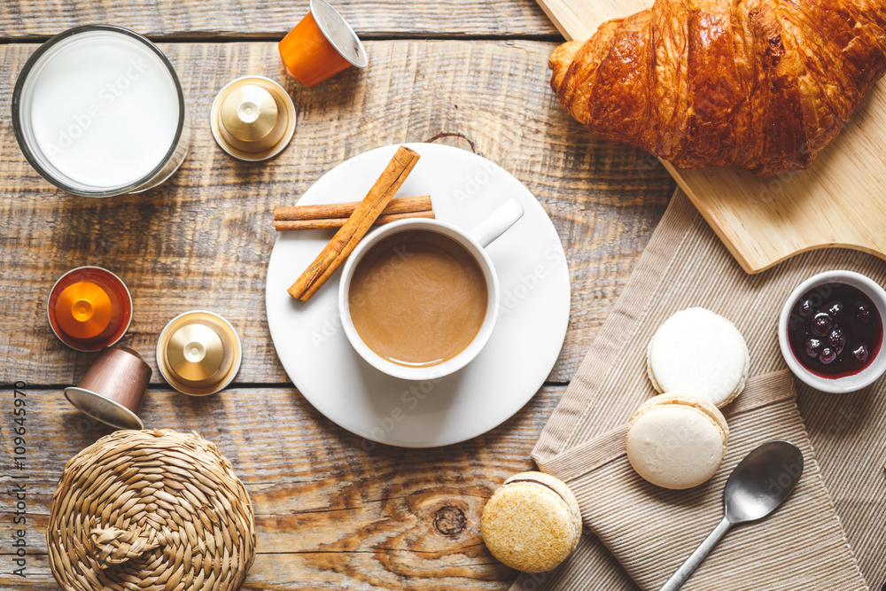 sweet breakfast with coffee, macaroons and croissants on wooden table