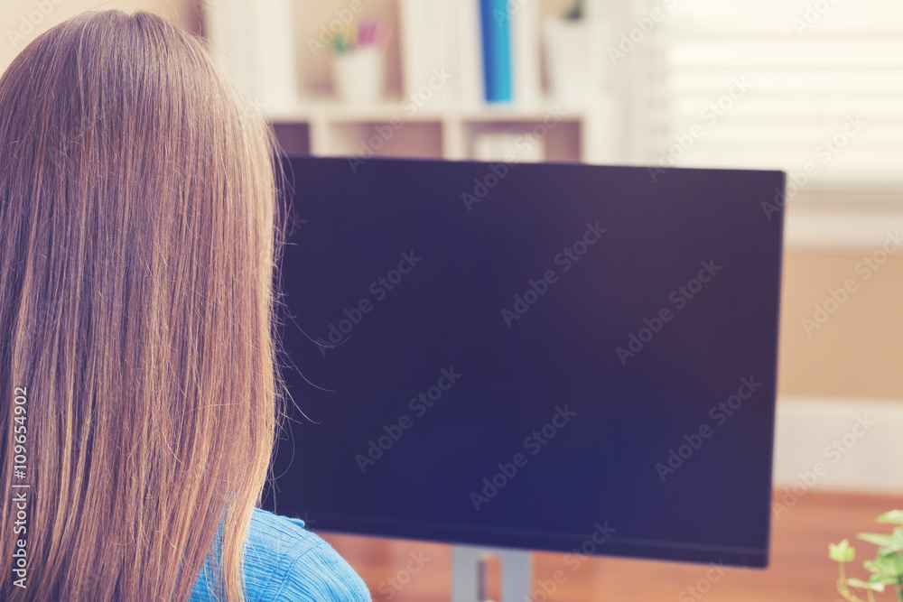 Woman working on her computer in her home office