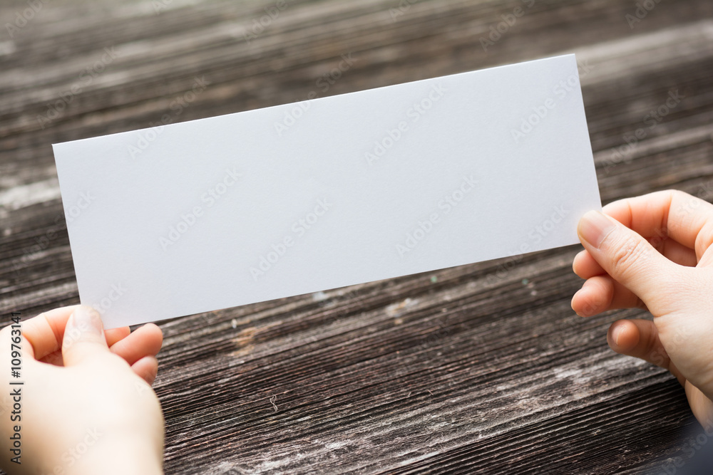 holds card with text on old wood plate