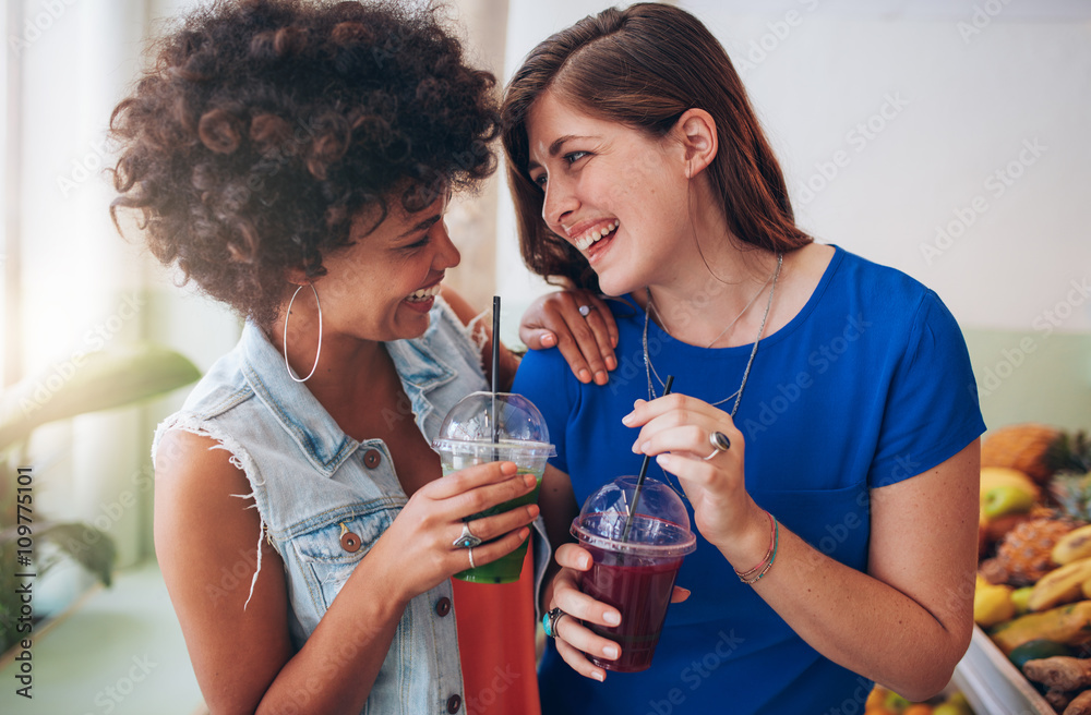 Cheerful young friends having fresh juice