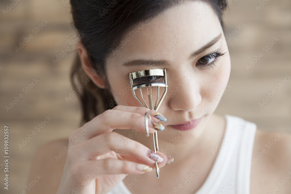 Women are curled eyelashes using eyelash curler