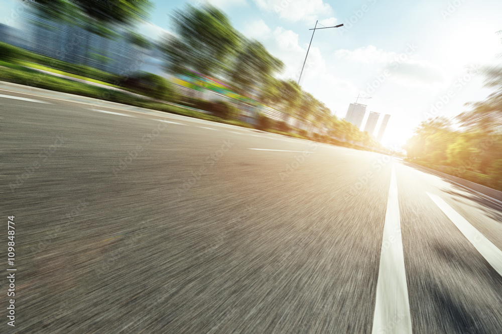 empty asphalt road in modern city at sunrise