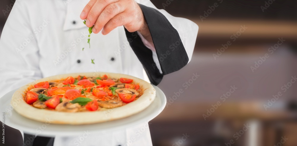 Composite image of close up on a chef holding a pizza