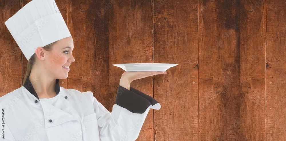 Composite image of woman chef holding a plate