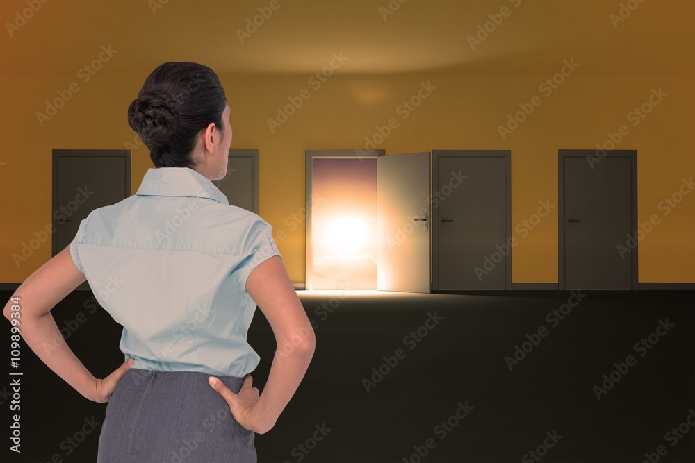 Composite image of rear view of businesswoman standing with hand