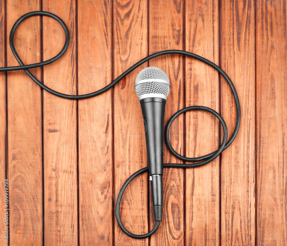 Microphone on wooden background