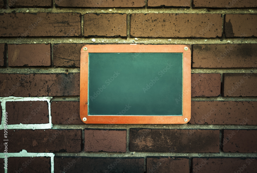 Tafel an einer Ziegelwand / Leere Tafel an einer Ziegelwand mit Textfreiraum.