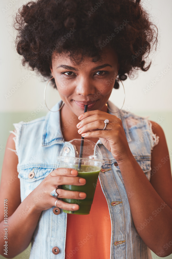 Attractive african woman drinking fresh fruit juice