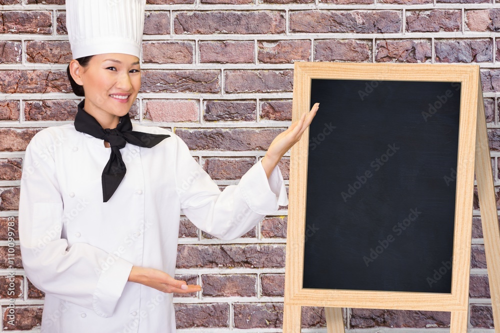 Composite image of portrait of a smiling female cook in kitchen