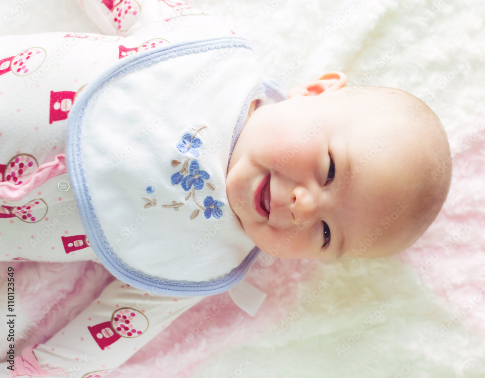 Happy baby girl lying on her blanket