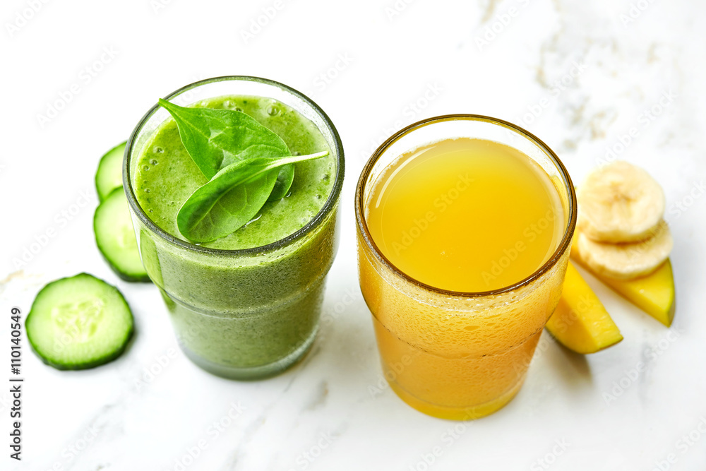 Glasses of green smoothie and yellow juice