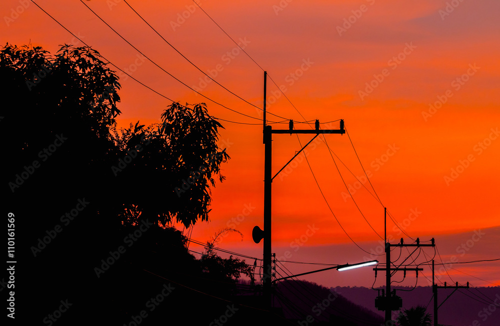 silhouettes of high voltage power lines on sunset