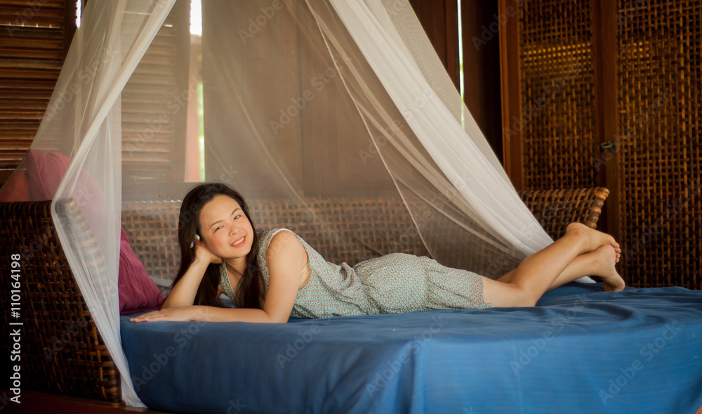 Asian woman relaxing on boutique bed