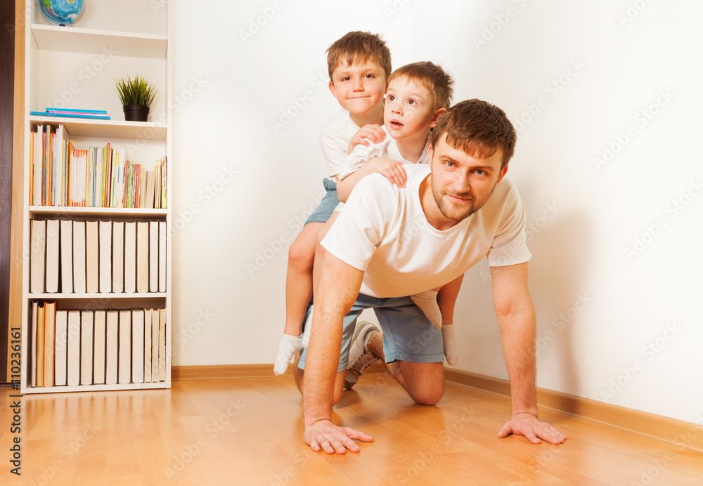 Father giving his two sons piggy back ride