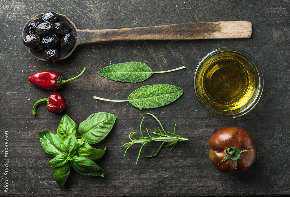 Vegetables and herbs on dark rustic wooden background. Greek black olives, fresh green sage, rosemar