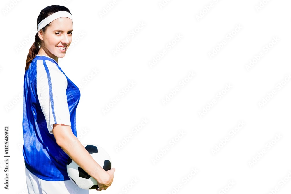 Woman soccer player posing with a ball