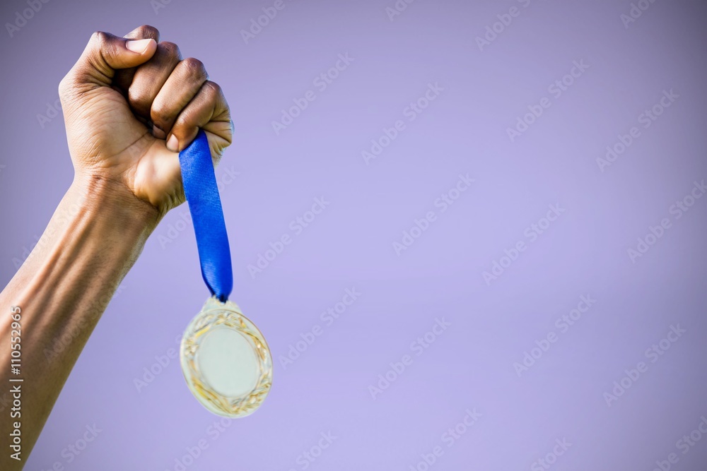 Composite image of hand holding a silver medal on white backgrou