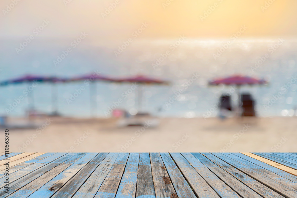 Wood floor on blurred sand beach background.