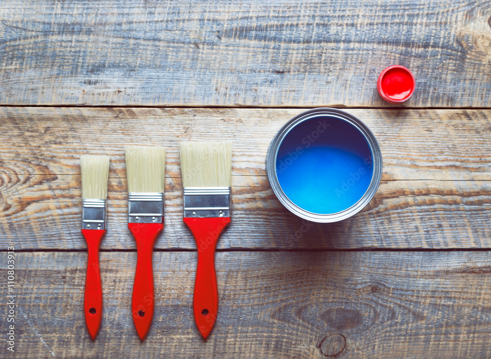 concept preparation for painting with  can of blue paint