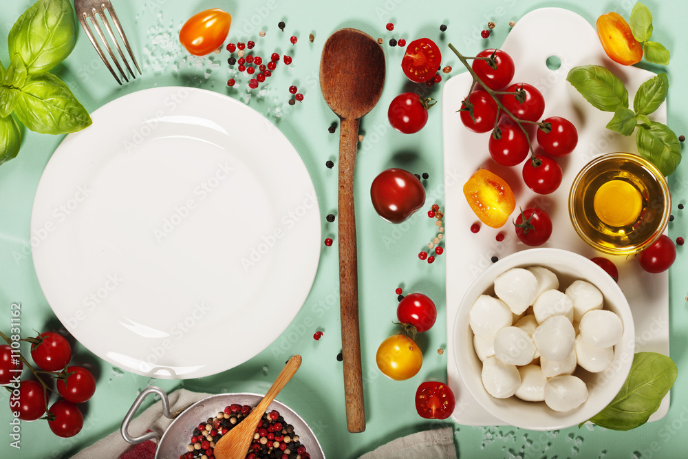 White ceramic serving board and salad ingredients over light blu