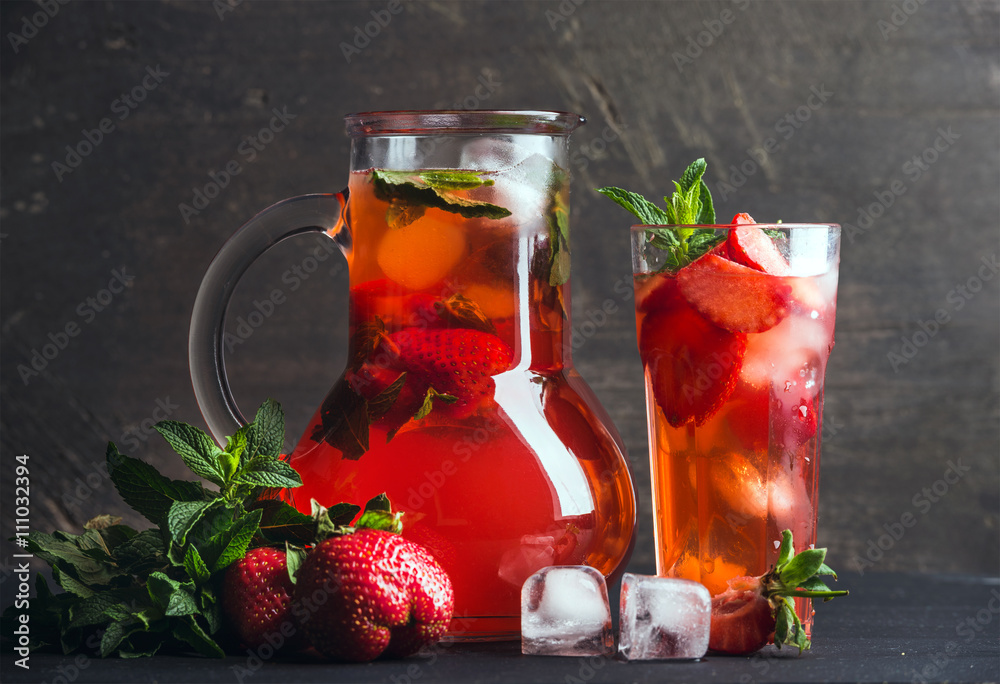 Homemade mint strawberry lemonade on dark wooden background