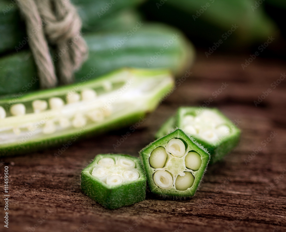 Close up fresh okra on wooden plate