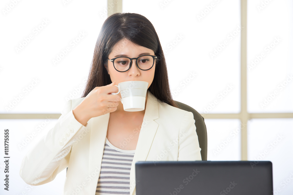 Asian business women working and drinking coffee on laptop