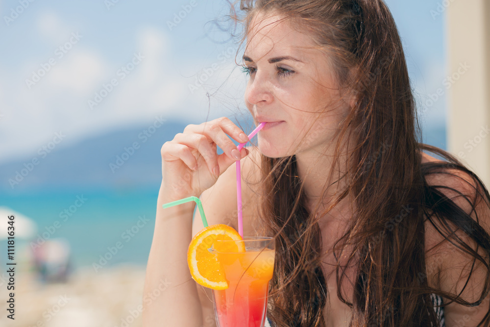 Woman with cocktail in the beach bar during tropical vacation