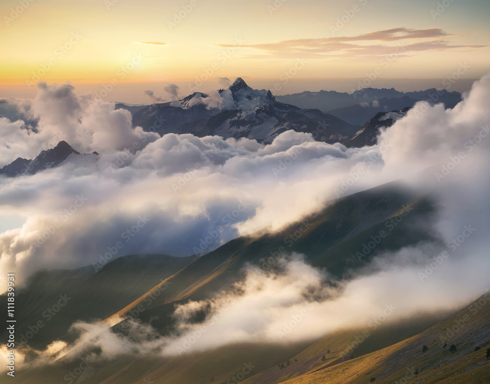 日出时云端的高山山脊。美丽的全景景观