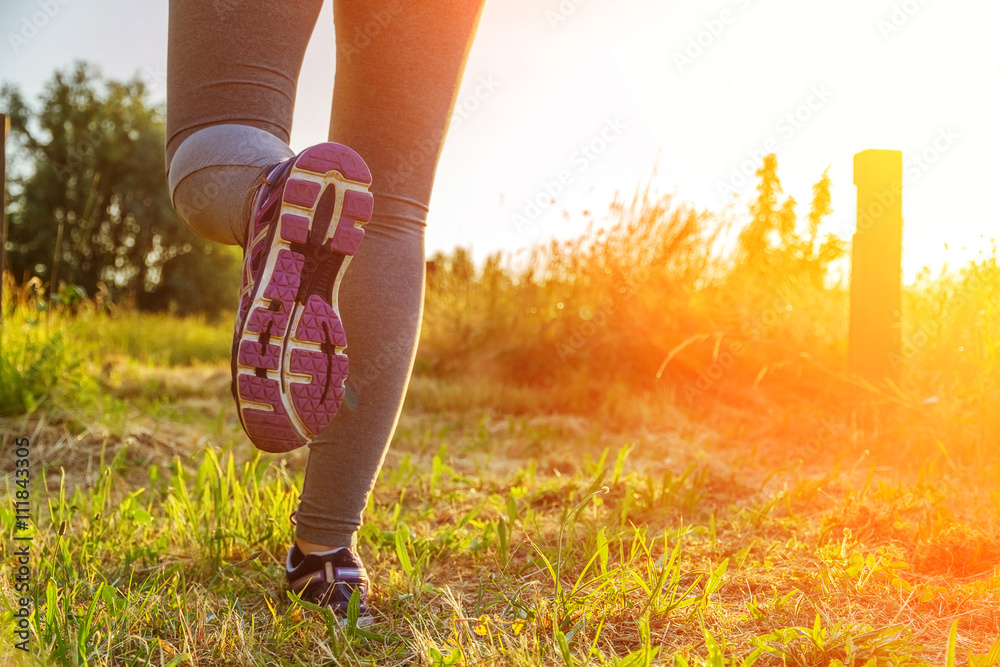 Woman running at sunset in a field