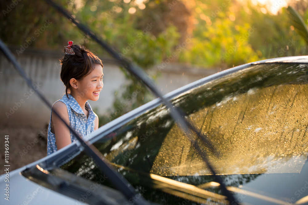 快乐的亚洲女孩在家泼水和阳光下洗车