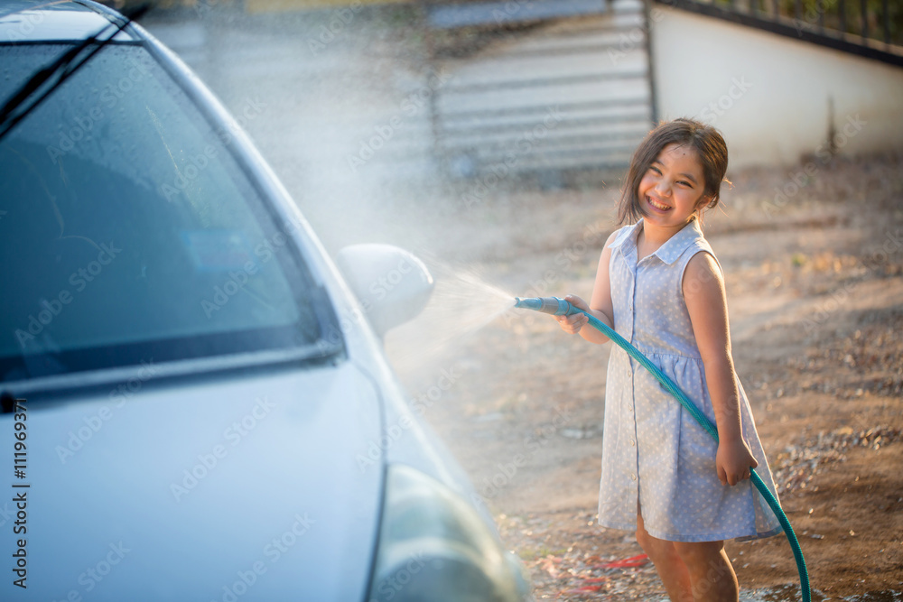 快乐的亚洲女孩在家泼水和阳光下洗车