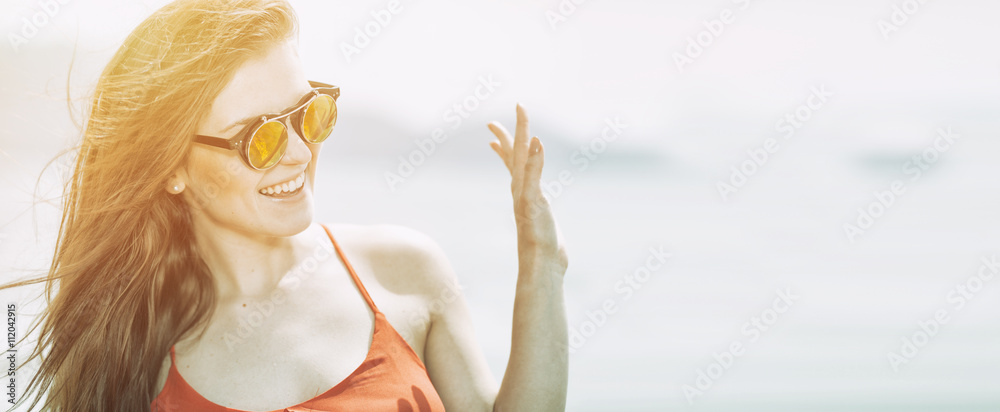 Young woman on the beach in hot summer sun light